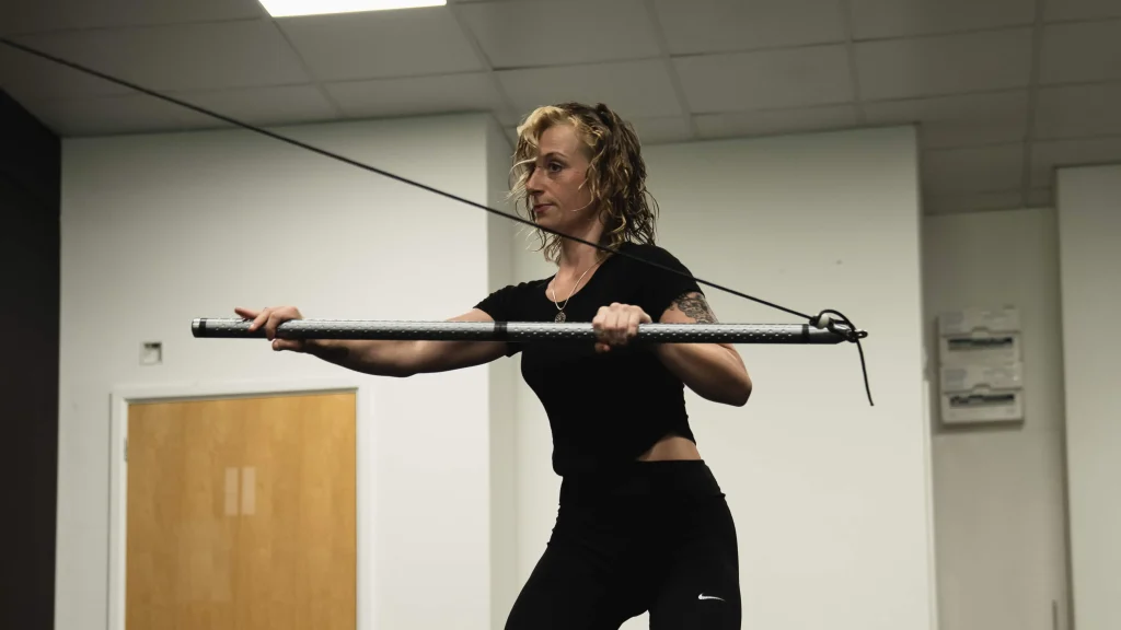 A Bristol Biomechanics coach assessing a client's posture and upper back alignment