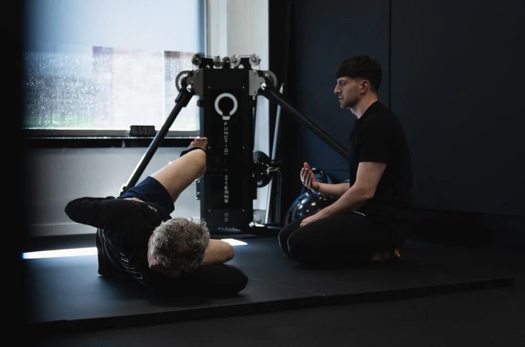 A coach guiding a client through a Functional Patterns corrective exercise session at Bristol Biomechanics