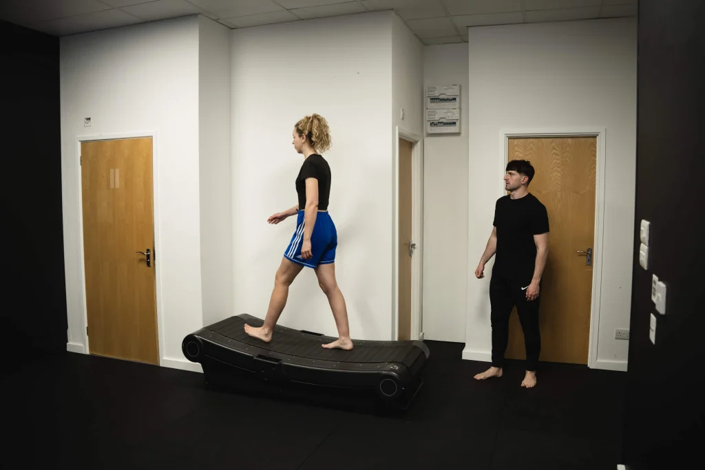 A Bristol Biomechanics coach observing a client's gait cycle on a treadmill during an assessment