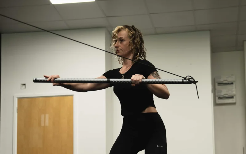 A Bristol Biomechanics coach assessing a client's posture and upper back alignment