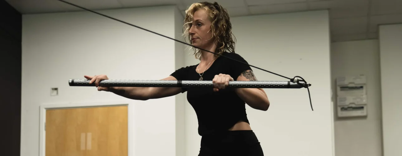 A Bristol Biomechanics coach assessing a client's posture and upper back alignment