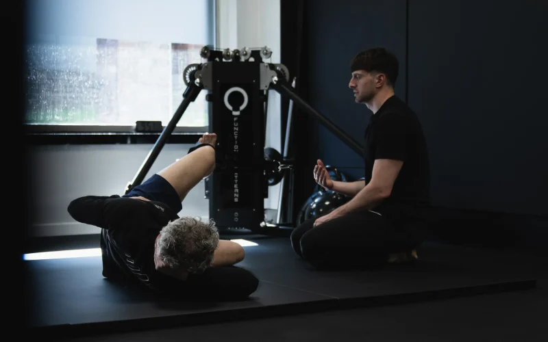 A coach guiding a client through a Functional Patterns corrective exercise session at Bristol Biomechanics