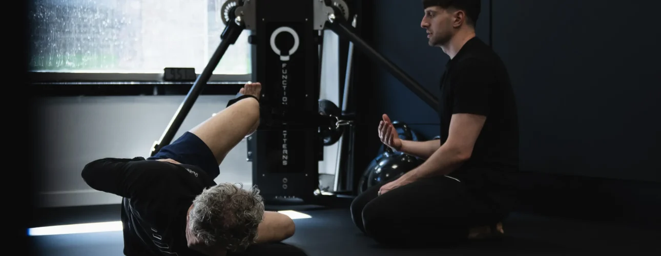 A coach guiding a client through a Functional Patterns corrective exercise session at Bristol Biomechanics