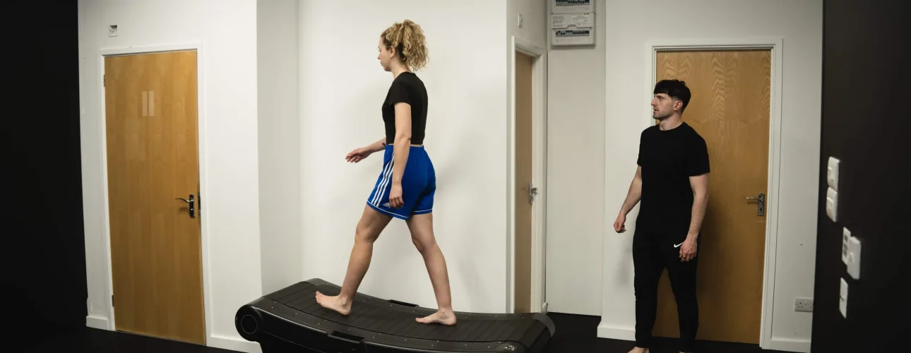 A Bristol Biomechanics coach observing a client's gait cycle on a treadmill during an assessment